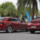 Two of VinFast's internal combustion cars parked under palm trees.